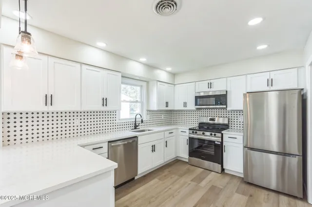 a kitchen with stainless steel appliances a refrigerator sink and microwave