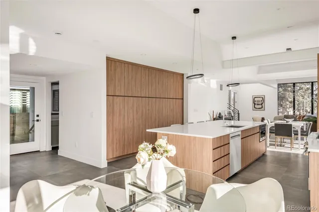 a kitchen with a dining table chairs and white appliances