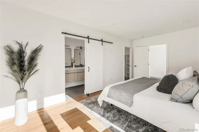 a bedroom with a large bed and a potted plant