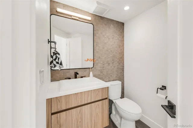 a bathroom with a sink a toilet and mirror