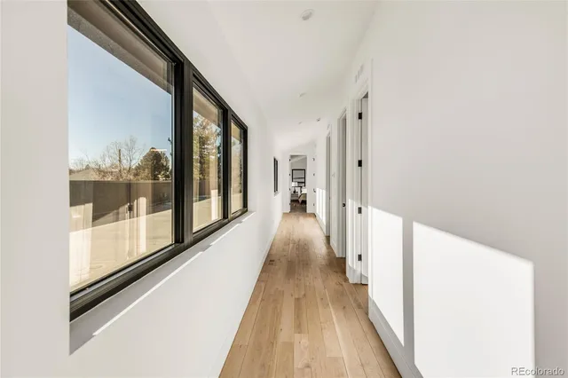 a view of a hallway with wooden floor and glass door