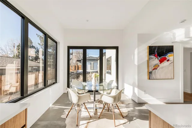 a dining room with furniture and large window