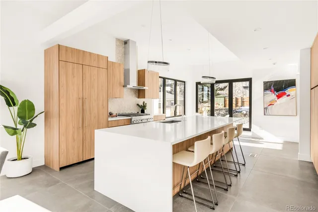 a large white kitchen with a large window