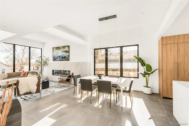 a living room with furniture large window and wooden floor
