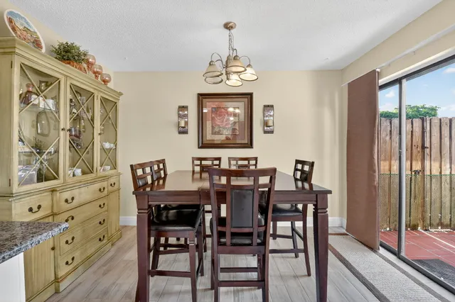 a view of a dining room and livingroom with furniture wooden floor a chandelier