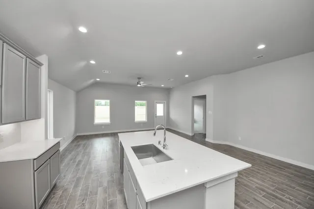 a view of an empty room and a kitchen