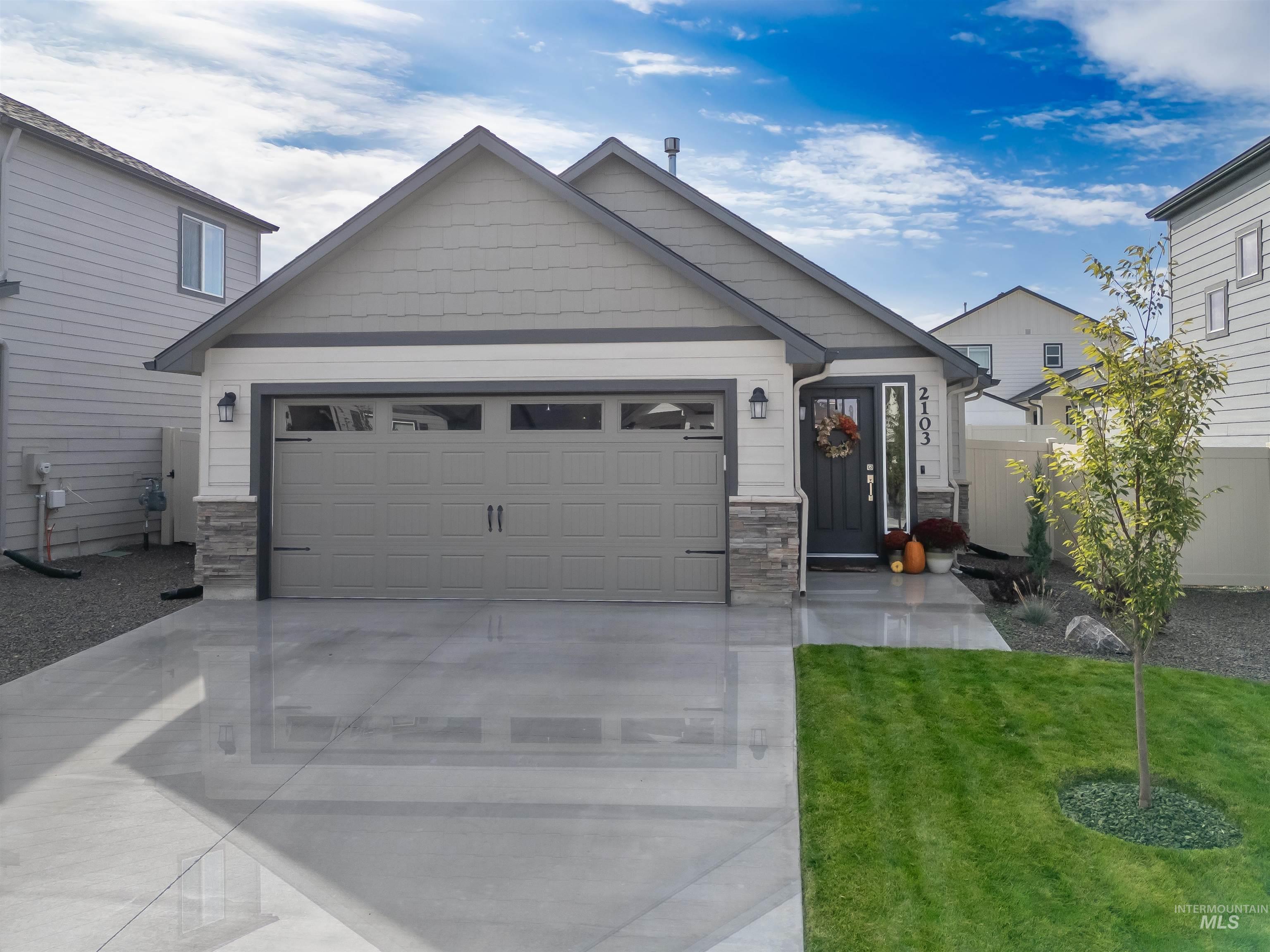2103 East Pilsner Street Kuna, ID 83634 - Photo 1 of 1 Craftsman-style house featuring stone siding, concrete driveway, an attached garage, and a front lawn