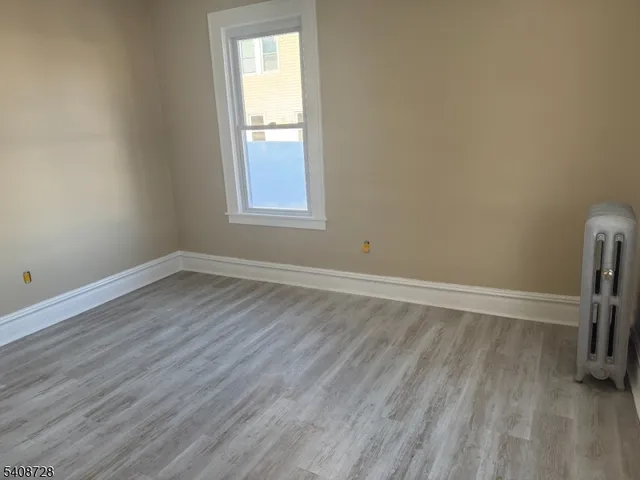 an empty room with wooden floor and a window