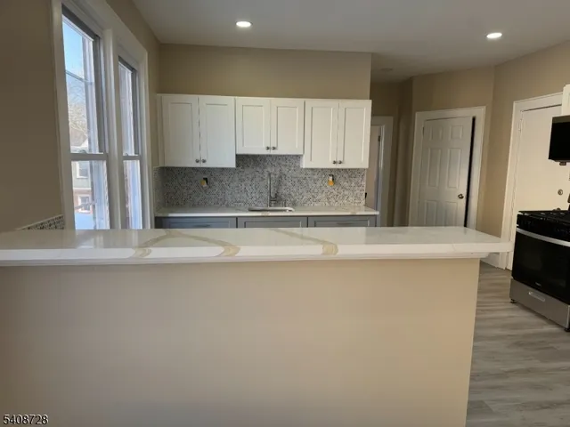 a kitchen with stainless steel appliances granite countertop a sink a stove and a refrigerator