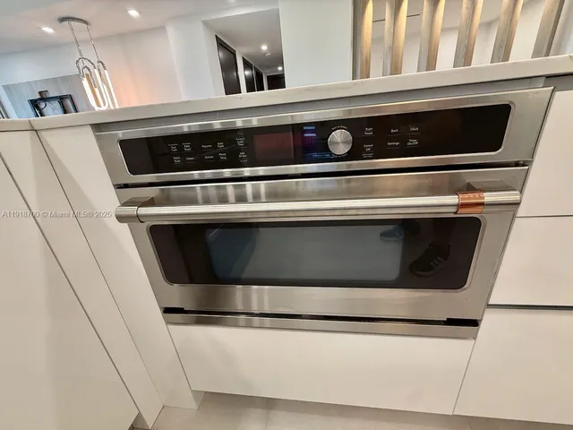 a kitchen with granite countertop a refrigerator and wooden cabinets