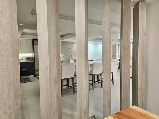 a dining room with furniture and a floor to ceiling window