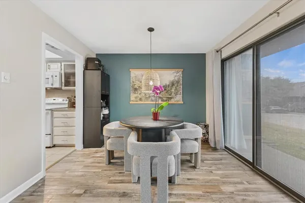a dining room with furniture a chandelier and wooden floor