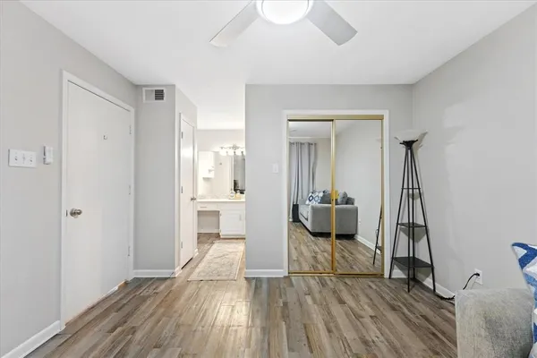 a view of a room with wooden floor and a bathroom