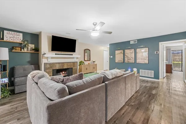 a living room with furniture a flat screen tv and a fireplace
