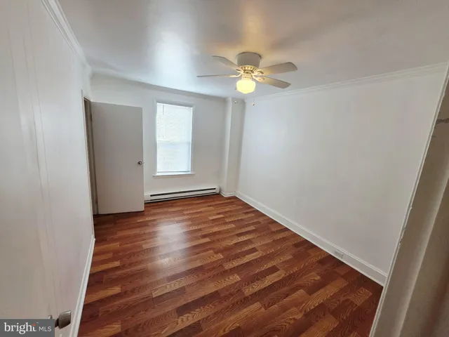 an empty room with wooden floor and window