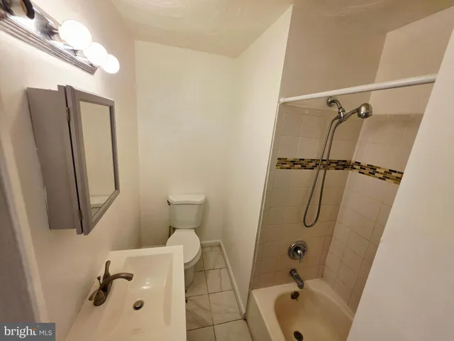 a bathroom with a granite countertop sink a toilet and shower