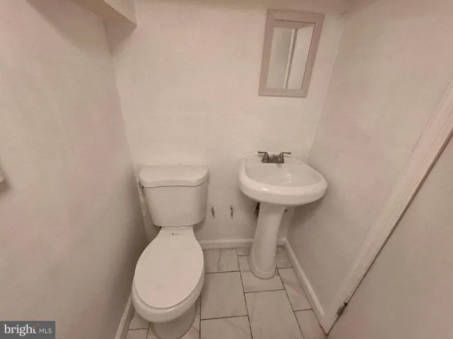 a bathroom with a sink toilet and a mirror