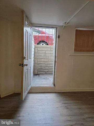 a view of water heater room with wooden floor