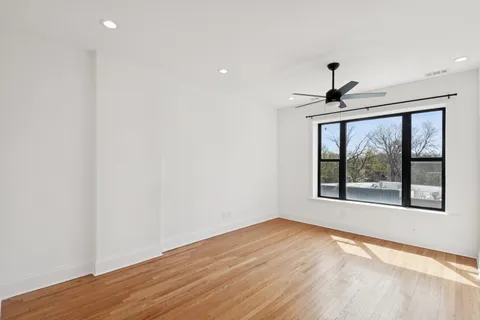 a view of an empty room with a window and a ceiling fan