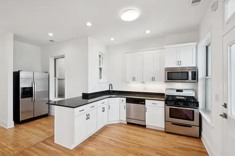 a large kitchen with cabinets stainless steel appliances and a counter space