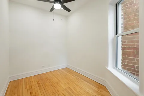 a view of a room with a window and wooden floor