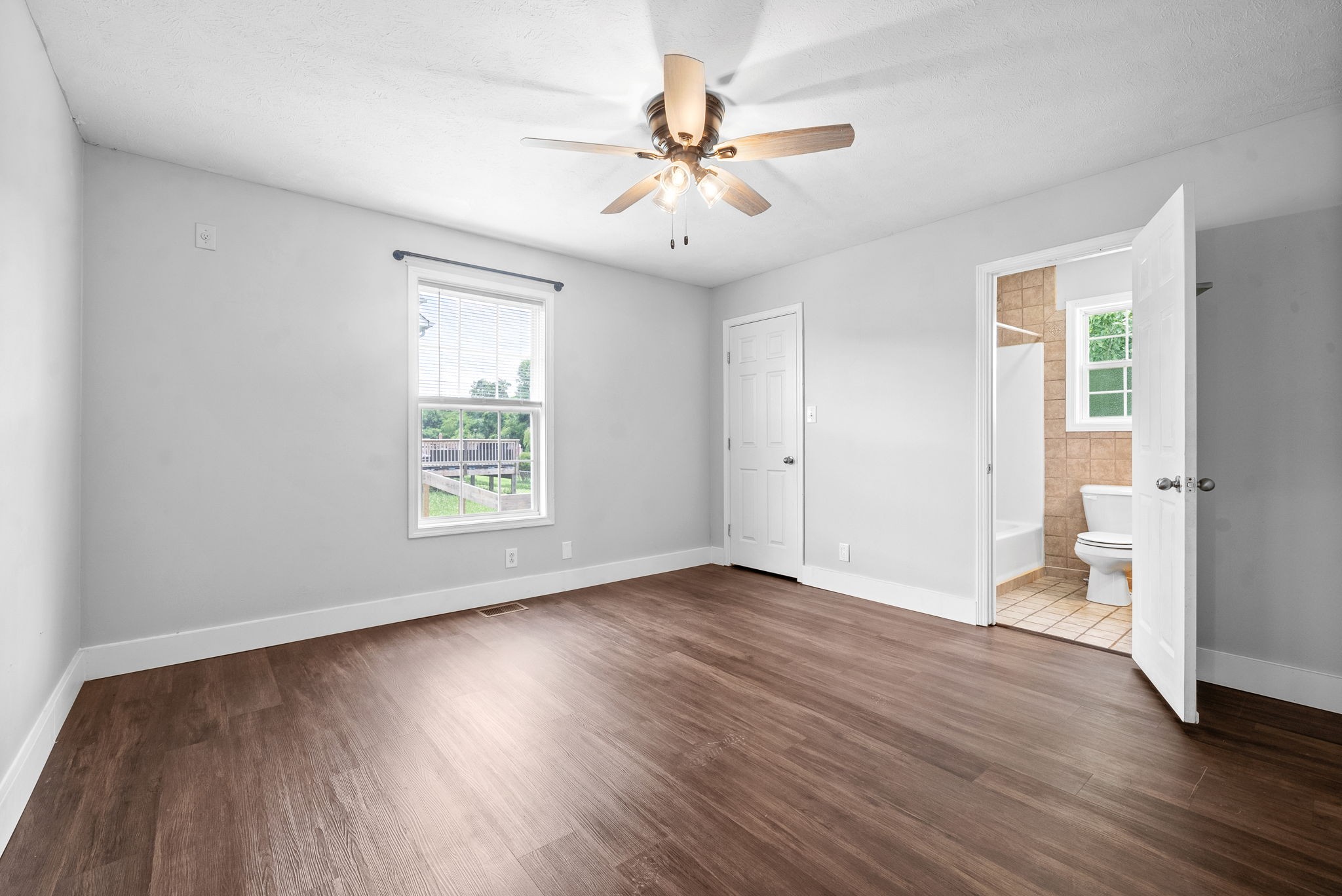 10383 Bell Station Road Oak Grove, KY 42262 - Photo 17 of 33 an empty room with wooden floor chandelier fan and windows