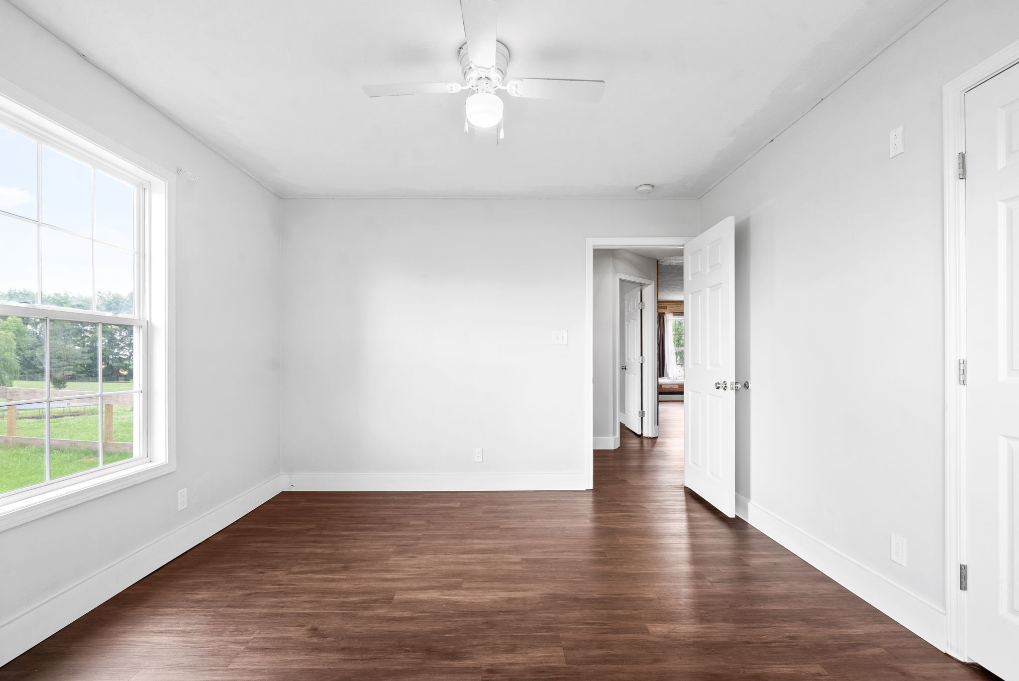 10383 Bell Station Road Oak Grove, KY 42262 - Photo 22 of 33 a view of an empty room with wooden floor and a window