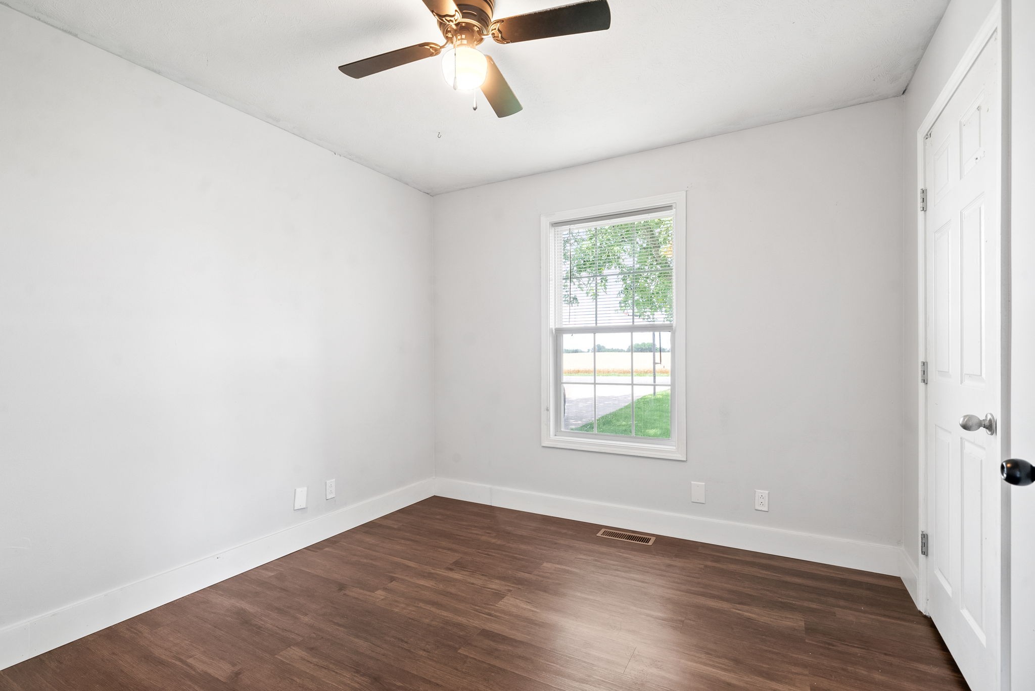 10383 Bell Station Road Oak Grove, KY 42262 - Photo 24 of 33 an empty room with wooden floor fan and windows