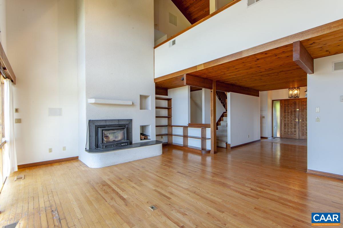 2900 Riggory Ridge Road Charlottesville, VA 22911 - Photo 14 of 44 an empty room with wooden floor fireplace and windows