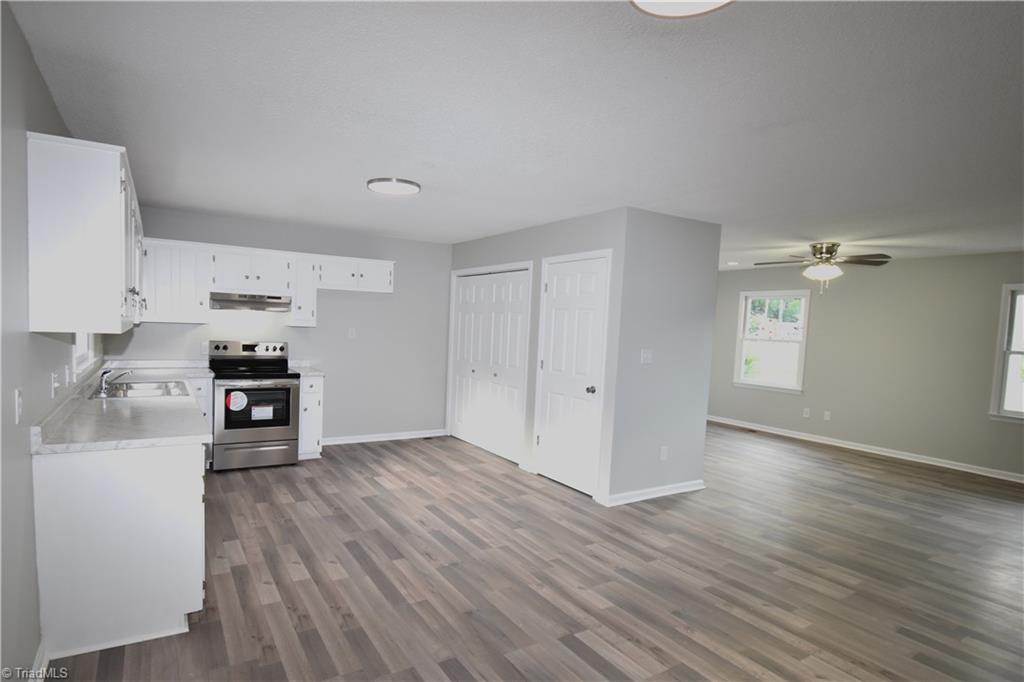 7211 Mason Road Climax, NC 27233 - Photo 7 of 31 The kitchen features a large pantry and the laundry area. The updated lighting gives this kitchen that modern clean feeling.