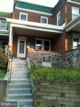 1213 West Old Cold Spring Lane Baltimore, MD 21211 - Photo 1 of 15 a front view of a house with a yard