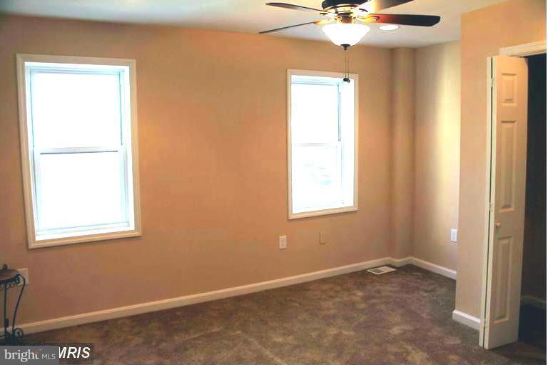 1213 West Old Cold Spring Lane Baltimore, MD 21211 - Photo 7 of 15 an empty room with a window and a chandelier fan