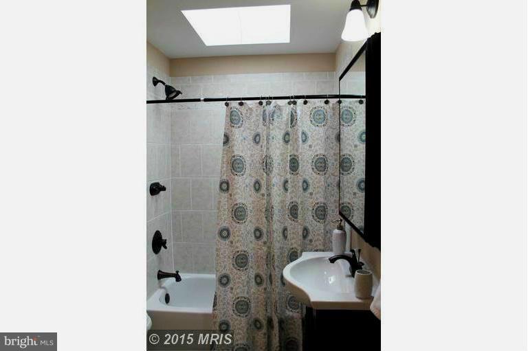 1213 West Old Cold Spring Lane Baltimore, MD 21211 - Photo 10 of 15 a bathroom with a sink and mirror