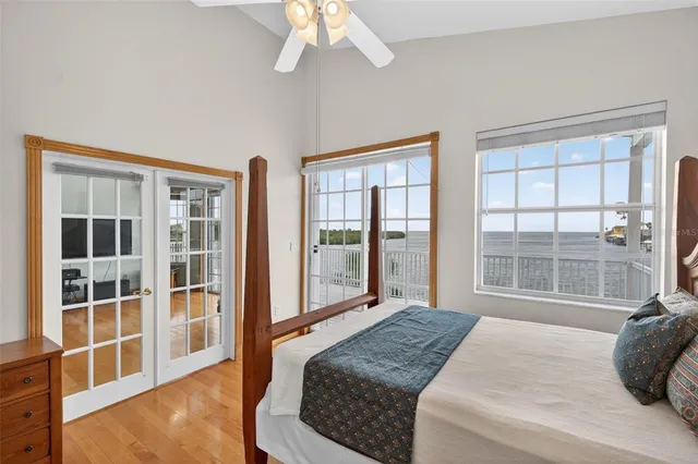 a view of a hallway with wooden floor and a bathroom