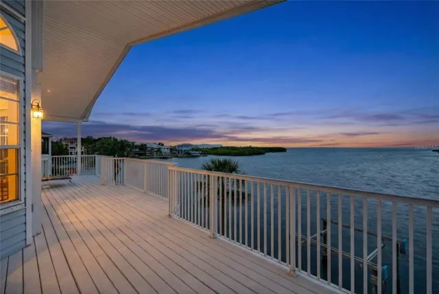 a view of a balcony with wooden floor and fence