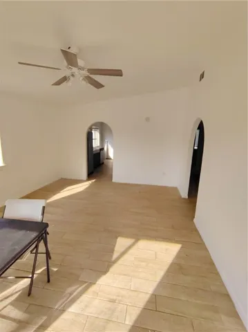 a view of a livingroom with wooden floor and a ceiling fan