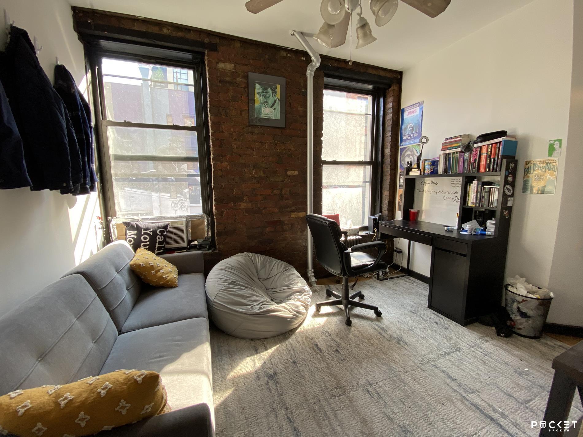 a livingroom with workspace and a window