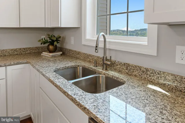 a bathroom with a granite countertop sink mirror vanity and toilet