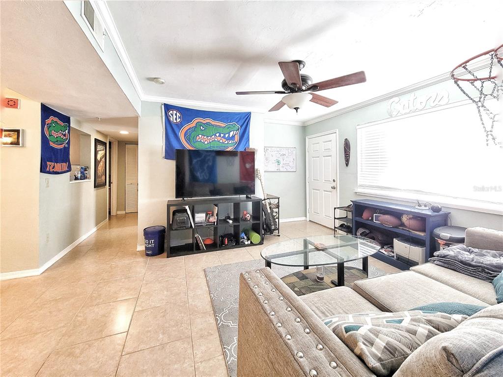 2360 Southwest Archer Road, Unit 801 Gainesville, FL 32608 - Photo 13 of 27 a bedroom with furniture and a flat screen tv