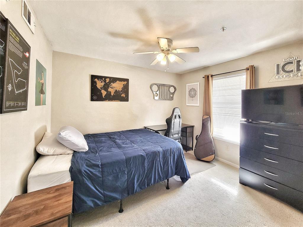 2360 Southwest Archer Road, Unit 801 Gainesville, FL 32608 - Photo 22 of 27 a spacious bedroom with a bed and ceiling fan