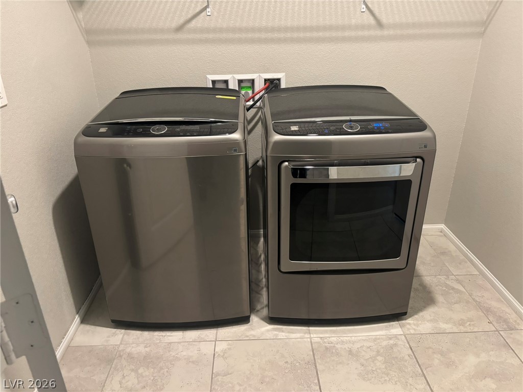 916 Riggs Flats Avenue North Las Vegas, NV 89086 - Photo 16 of 43 Tiled flooring and a wire storage shelf anchor this dedicated laundry alcove.