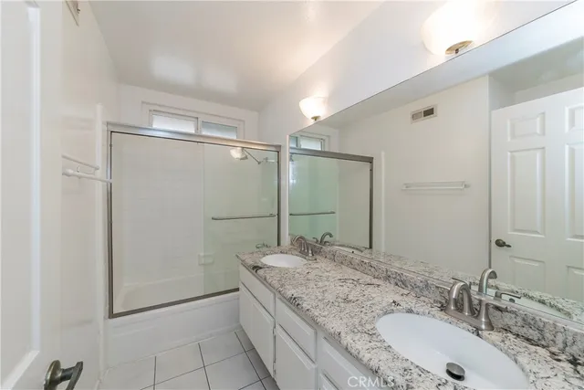 a bathroom with a granite countertop shower sink and mirror