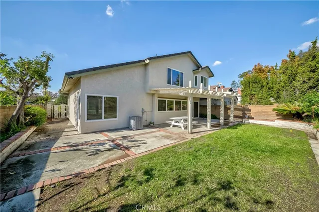a patio with table and chairs and potted plants