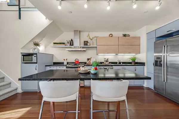 a kitchen with stainless steel appliances granite countertop a sink and a refrigerator