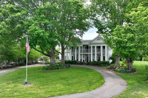 a view of a house with a backyard and a tree