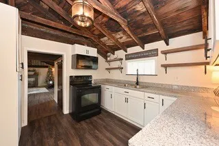 a kitchen with wooden cabinets a sink dishwasher and a stove with wooden floor