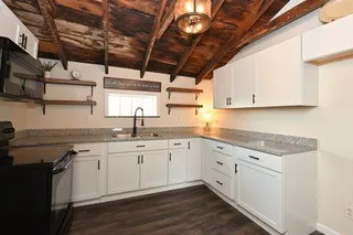 a kitchen with stainless steel appliances granite countertop a refrigerator a sink dishwasher and wooden cabinets with wooden floor