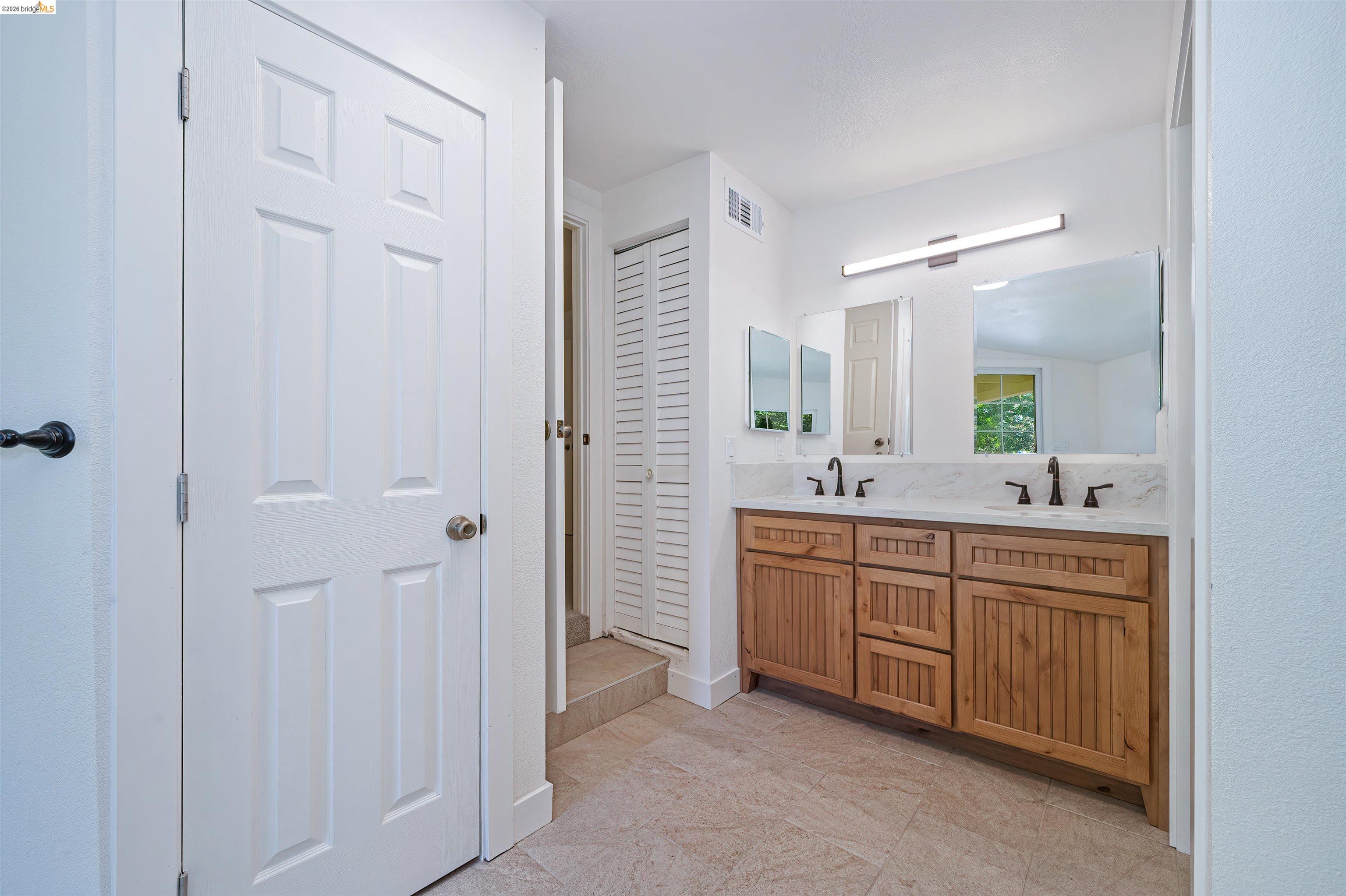 10474 Sheldon Road Elk Grove, CA 95624 - Photo 35 of 83 Dual sink vanity featuring wood-finish cabinetry, white countertop, and matte black fixtures
