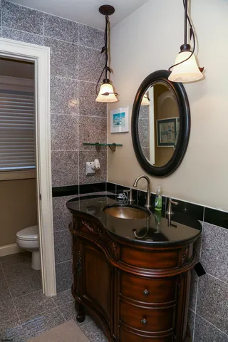 a bathroom with a toilet mirror and vanity