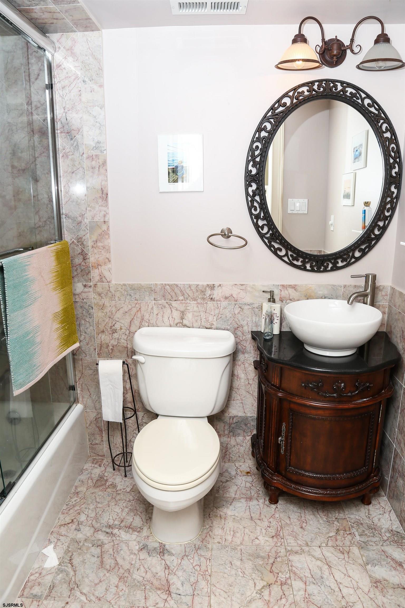 339 South 13th Street Brigantine, NJ 08203 - Photo 19 of 57 a bathroom with a toilet mirror and vanity